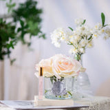 Glass vase with white roses on a table with a blurred background